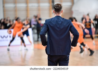 Head coach back's and basketball match in the background. - Powered by Shutterstock