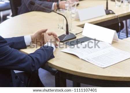 The head of the company is sitting at the table at a business briefing. Close-up of hands