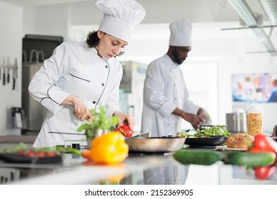 Head cook in professional kitchen cooking organic food while cutting fresh vegetables. Sous chef chopping red pepper vegetable for gourmet dish served at dinner in restaurant - Powered by Shutterstock