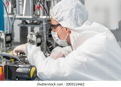 The Head Of The Engine Technician, Wearing A Protective Suit, Inspects, Repairs, Maintains The Machines, Produces Quality Slide Products And Gets The Job Done On Time In The Medical Device Factory. 