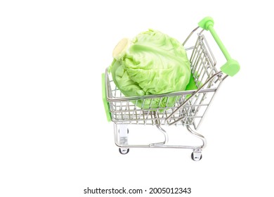 A Head Of Fresh Young Cabbage In A Toy Shopping Trolley Isolated On White