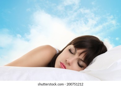 head girl sleeping on pillow with blue sky in background