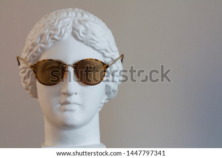 the head of the Greek goddess Muse wearing sunglasses