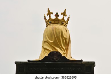 Head Of King Wearing Gold Crown And Yellow Veil While Sitting On Brown Chair