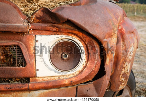 A head\
lamp of an old Pickup truck, rusty and\
moldy