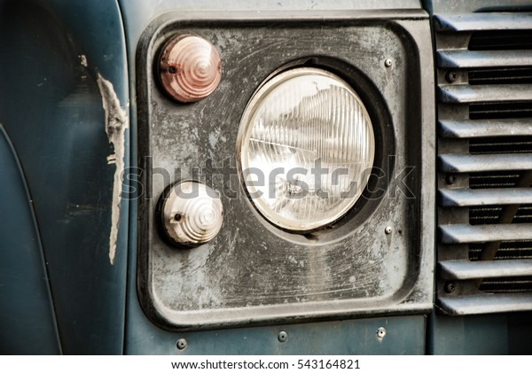 Head lamp on\
blue truck with dent high\
contrast