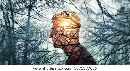 Head of a man on background of trees in forest. Concept on topic of psychology, psychiatry, depression. The branches of trees symbol problems and diseases and sun is a symbol of hope and recovery.
