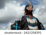 Head of Native American woman in traditional costume against cloudy sky