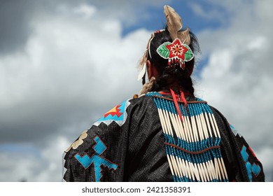 Head of Native American woman in traditional costume against cloudy sky