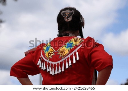 Head of Native American woman in traditional costume against cloudy sky