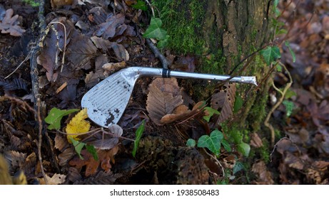 Head Of Old Discarded Golf Club Lying On Ground In Autumn Foliage