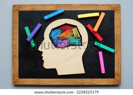 Head is painted with colored crayons. Neurodivergent concept.