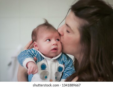 Head Portrait Of Mum Kissing Her Baby Newborn, Mother Is Holding Her Little Baby Boy