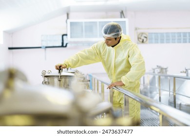 Head of quality control officer examines inside the food and beverage manufacturing factory. Female food scientist is checking a fermentation tank in the beverage factory. - Powered by Shutterstock