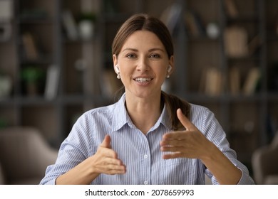 Head shot attractive businesswoman sit indoor looks at camera talks through video call. Female counsellor wear wireless earphones provide support help to client remotely. Virtual meeting event concept - Powered by Shutterstock