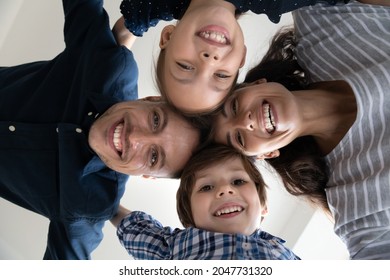 Head Shot Bottom View Joyful Young Latin Couple Parents Joining Heads With Laughing Adorable Son And Daughter, Posing For Photo. Happy Bonding Family Showing Support And Care, Relations Concept.