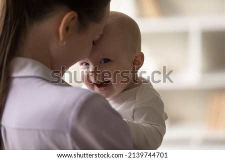 Head shot close up affectionate young mother holding adorable cute newborn baby son daughter, expressing sincere loving feelings, enjoying sweet tender moment together at home, devotion concept.