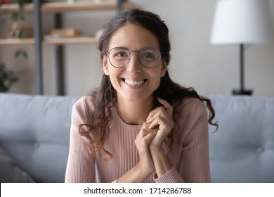 Head Shot Close Up Beautiful Smiling Young Woman In Eyewear Looking At Camera, Holding Video Job Interview From Home. Web Cam View Happy Smart Female Blogger Recording Vlog Alone In Living Room.