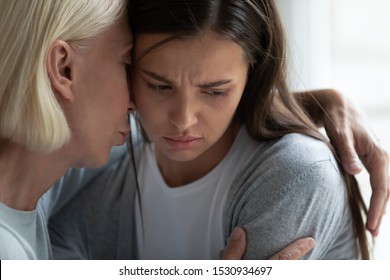 Head shot close up empathic middle aged woman hugging upset desperate depressed worrying grown up daughter, calming her down, showing love care, supporting in difficult life situation, giving advices. - Shutterstock ID 1530934697