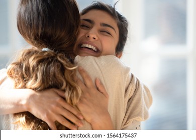 Head shot close up happy mixed race girl cuddling smiling indian female friend. Overjoyed excited best buddies emracing hugging, greeting each other with success, true strong friendship concept. - Shutterstock ID 1564175437