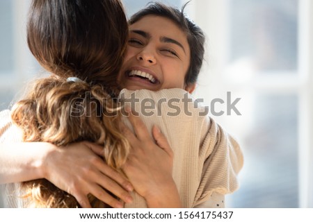 Head shot close up happy mixed race girl cuddling smiling indian female friend. Overjoyed excited best buddies emracing hugging, greeting each other with success, true strong friendship concept. Stock photo © 