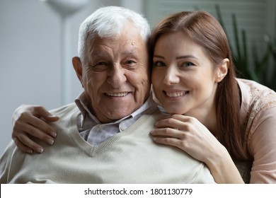 Head Shot Close Up Portrait Of Affectionate Grown Up Daughter Embracing Shoulders Of Happy Old Mature Retired Father, Showing Love And Care, Posing For Family Photo, Enjoying Sweet Tender Moment.