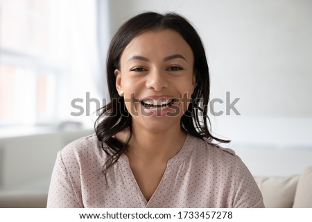 Head shot close up portrait African ethnicity woman sitting on couch takes part in videocall chatting with foreign friend webcam view, passes job interview distantly, blogger record new vlog concept Stock photo © 