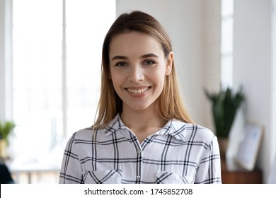 Head shot close up portrait of happy young female company employee worker. Smiling millennial businesswoman trainer lecturer coach teacher financial advisor looking at camera, standing in office. - Shutterstock ID 1745852708