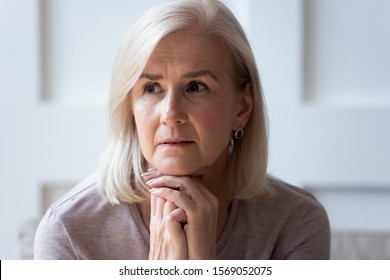 Head Shot Close Up Portrait Thoughtful Middle Aged Retired Woman Worrying About Personal Health Problems. Upset Older Female Retiree Thinking Of Family Troubles, Feeling Lonely, Sitting At Home.