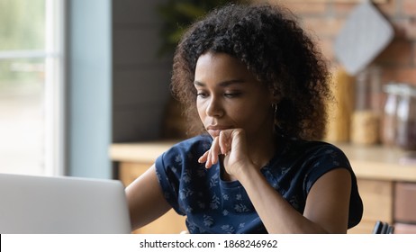 Head Shot Close Up Thoughtful Young African American Woman Looking At Computer Screen, Thinking On Problem Solution, Involved In Working Distantly Online At Home Office, Freelance Workday Concept.