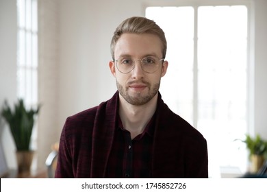 Head Shot Close Up Young Blonde Employee Worker In Glasses Looking At Camera. Portrait Of Millennial Colleague Coworker Designer Businessman Entrepreneur Posing For Photo In Light Workplace.