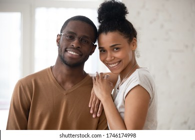 Head shot happy African ethnicity spouses portrait concept. Newly weds pose in rented flat, bank approved loan for young family. Pretty wife snuggles to husband in glasses people smile look at camera - Shutterstock ID 1746174998