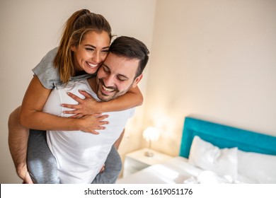 Head shot happy millennial young man and woman hugging embracing indoors. Portrait close up smiling husband and wife piggyback ride. Dating and romantic relationship concept - Shutterstock ID 1619051176
