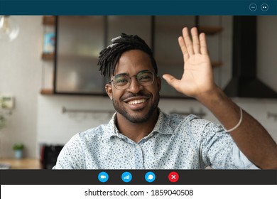Head shot happy young african ethnicity handsome bearded man in eyeglasses making hello hi gesture, greeting friend or colleagues at video call online meeting, modern distant communication concept.