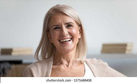 Head Shot Image Attractive 60s Blond Female With Wide Charming Candid Smile, Aged Woman Looks At Camera Smiling Takes Part In Photo Session Feels Healthy Satisfied Enjoy Retired Carefree Life Concept