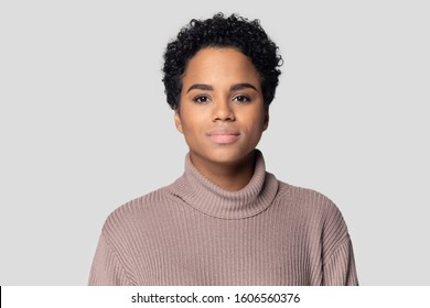 Head Shot Portrait African Young Woman Having Short Black Hairs Wears Knitted Sweater Posing Isolated On Gray Background, Serious Beautiful 20s Mixed-race Girl Look At Camera, Natural Beauty Concept