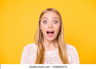 Head shot portrait of astonished surprised girl with wide open mouth eyes looking at camera isolated on vivid bright yellow background