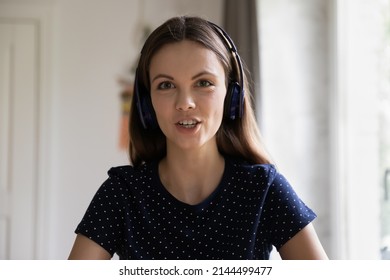 Head Shot Portrait Attractive Young Woman In Headphones Look At Camera Make Call Talk To Friend, Pass Job Interview Use Videocall App. Virtual Meeting, Young Gen Use Modern Tech, Communication Concept