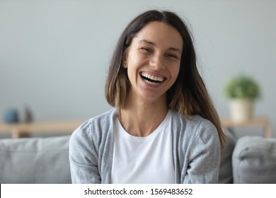 Head shot portrait beautiful happy laughing 30s woman in casual clothes smiles sit on couch looking at camera web cam view mixed-race female blogger share positive news record video feels overjoyed - Shutterstock ID 1569483652