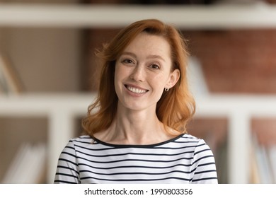 Head Shot Portrait Of Beautiful Smiling Young Red-haired Business Lady Posing In Office. Sincere Happy Attractive Millennial Generation Female Employee Worker Entrepreneur Expert Looking At Camera.