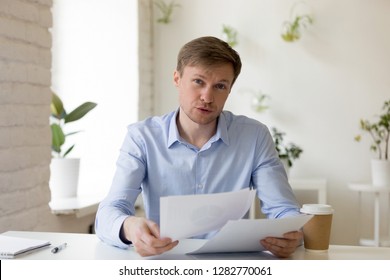 Head Shot Portrait Businessman Talking About Documents, Consulting Client, Looking At Camera, Serious Man Holding Paper In Hands, Discussing Financial Report, Explaining Task, Negotiations, Interview