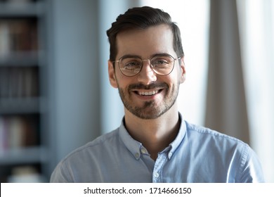 Head shot portrait close up smiling confident businessman wearing glasses looking at camera, standing in modern cabinet, successful happy young man, employee, worker in eyewear posing for photo - Shutterstock ID 1714666150