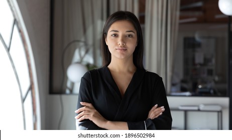 Head shot portrait confident Indian businesswoman hr manager standing in modern office with arms crossed, serious entrepreneur team leader mentor posing for corporate photo, looking at camera - Powered by Shutterstock