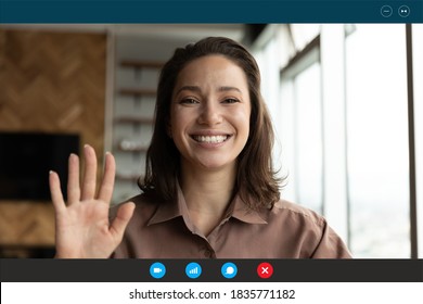 Head shot portrait device screen view smiling woman waving hand and looking at camera, greeting friends or relatives, making video call, using webcam and apps, engaged virtual conference