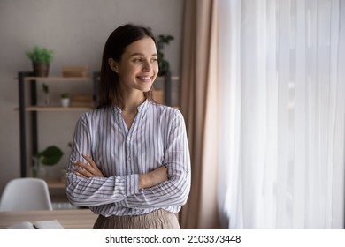 Head shot portrait of happy confident millennial businesswoman looking at window hands folded, thinking of project future vision, ambitious career, plan, goal, smiling. Business leader, leadership - Powered by Shutterstock