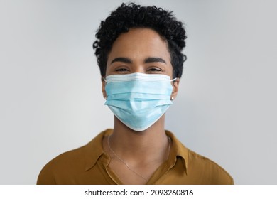 Head Shot Portrait Of Happy Millennial African American Woman Wearing Medical Protective Facemask Respirator, Preventing Coronavirus Infection Or Fighting With Air Pollution, Isolated On White Wall.