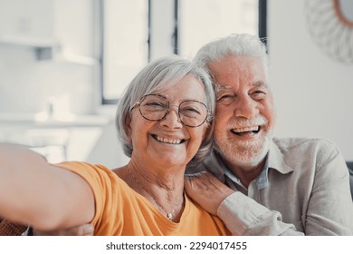 Head shot portrait happy senior couple taking selfie, having fun with phone cam, smiling aged wife and husband hugging, looking at camera, posing for photo, aged man vlogger recording video - Powered by Shutterstock