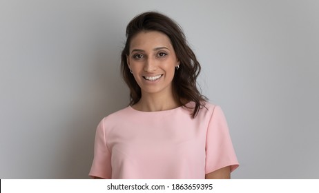 Head shot portrait of happy young arabic indian multiracial ethnicity beautiful woman with healthy shiny gloss hair and white toothy smile looking at camera, isolated on grey white studio background.