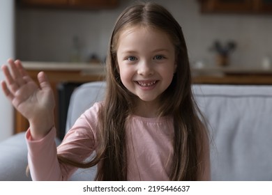 Head Shot Portrait Little Girl Raise Arm Makes Hello Gesture Start Videocall. Distancing Communication To Family Living Abroad, Blogging Activity, Young Generation Use Video Call Application Concept