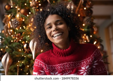 Head shot portrait overjoyed African American woman laughing, looking at camera, posing on Christmas tree background at home, blogger shooting vlog, having fun, using webcam, making video call - Powered by Shutterstock